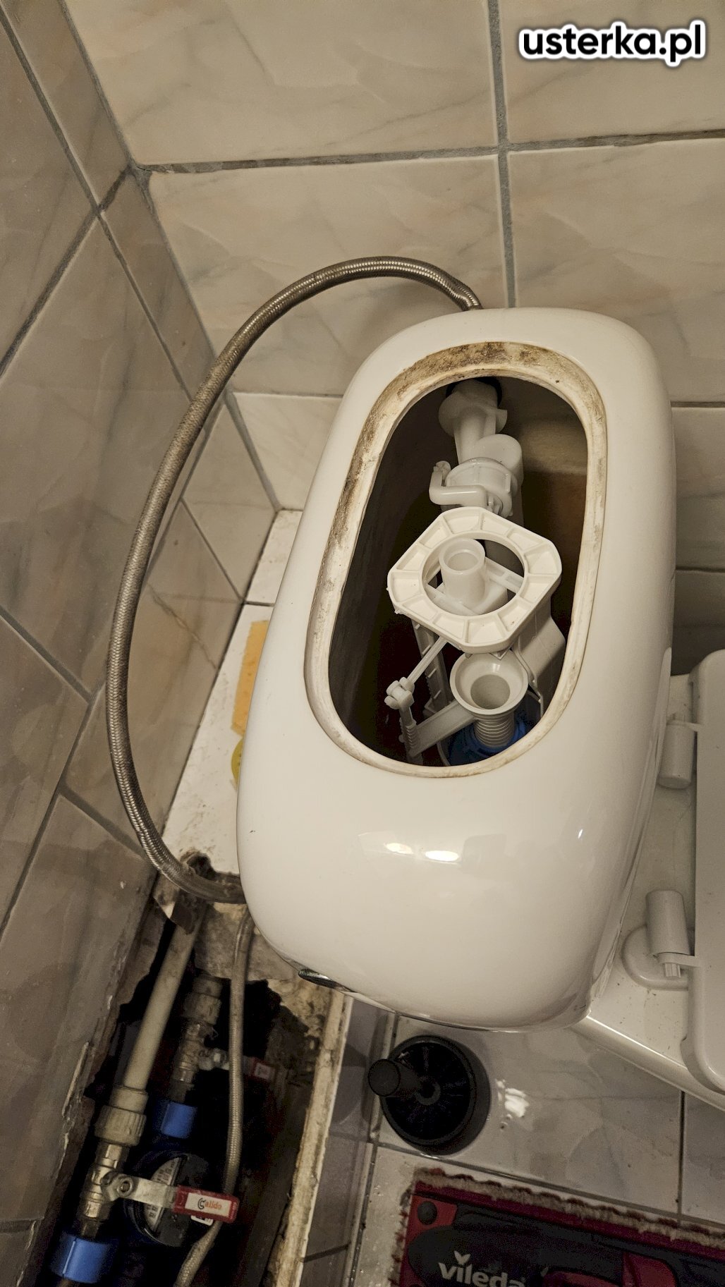 Po sprawdzeniu toalety wolnostojącej stwierdziłem, że mimo wymiany zaworów napełniającego i spustowego, woda nadal przepływa do muszli z powodu nieszczelności zaworu spustowego oraz zakamienienia spłuczki. Dodatkowo występuje wyciek z tyłu toalety, najprawdopodobniej spowodowany mikropęknięciem ceramiki lub uszkodzoną uszczelką między spłuczką a miską. Toaleta nie jest trwale przymocowana do podłoża, co również sprzyja wyciekom. Widoczne ślady korozji na pralce obok wskazują na długotrwałe problemy z przeciekaniem. Zalecam wymianę toalety na nową oraz wymianę zaworu doprowadzającego wodę i wężyka.
